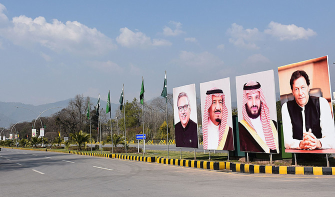 Pakistani commuters ride past billboards showing portraits of Saudi Arabian Crown Prince Mohammed bin Salman (2R) and Pakistan's Prime Minister Imran Khan (R) displayed on a roadside ahead of the prince's arrival in Islamabad on February 15, 2019. (AN Photo)