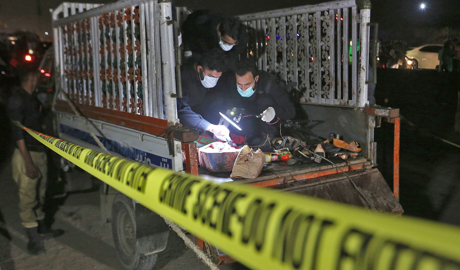 Pakistani investigators examine a truck at the site of an explosion, in Karachi, Pakistan, on August 14, 2021. (AP)