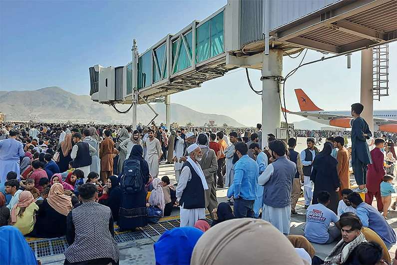 Afghans crowd at the tarmac of the Kabul airport on August 16, 2021. (AFP)
