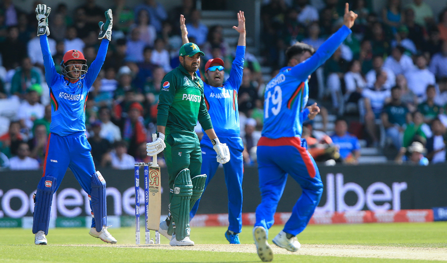 Afghanistan's Rashid Khan (R) makes a successful appeal for a leg before wicket decision against Pakistan's Haris Sohail (C) during the 2019 Cricket World Cup at Headingley, England, on June 29, 2019. (AFP/File)