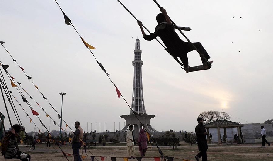 A Pakistani visitor swings in front of the Minar-i-Pakistan monument in Lahore on February 12, 2010. (AFP/ File)