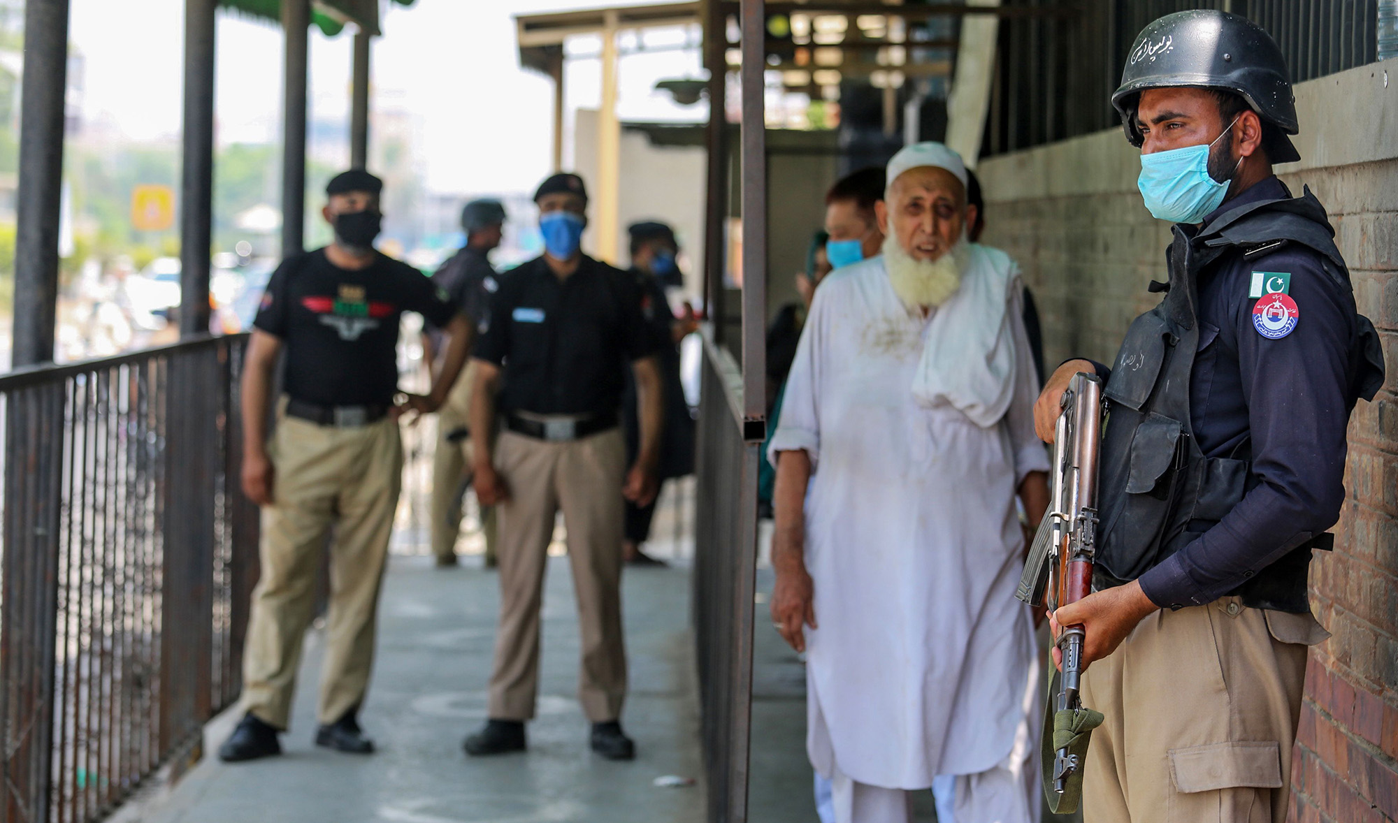 Security personnel stand guard outside the district court building in Peshawar on July 29, 2020. (AFP/File)
