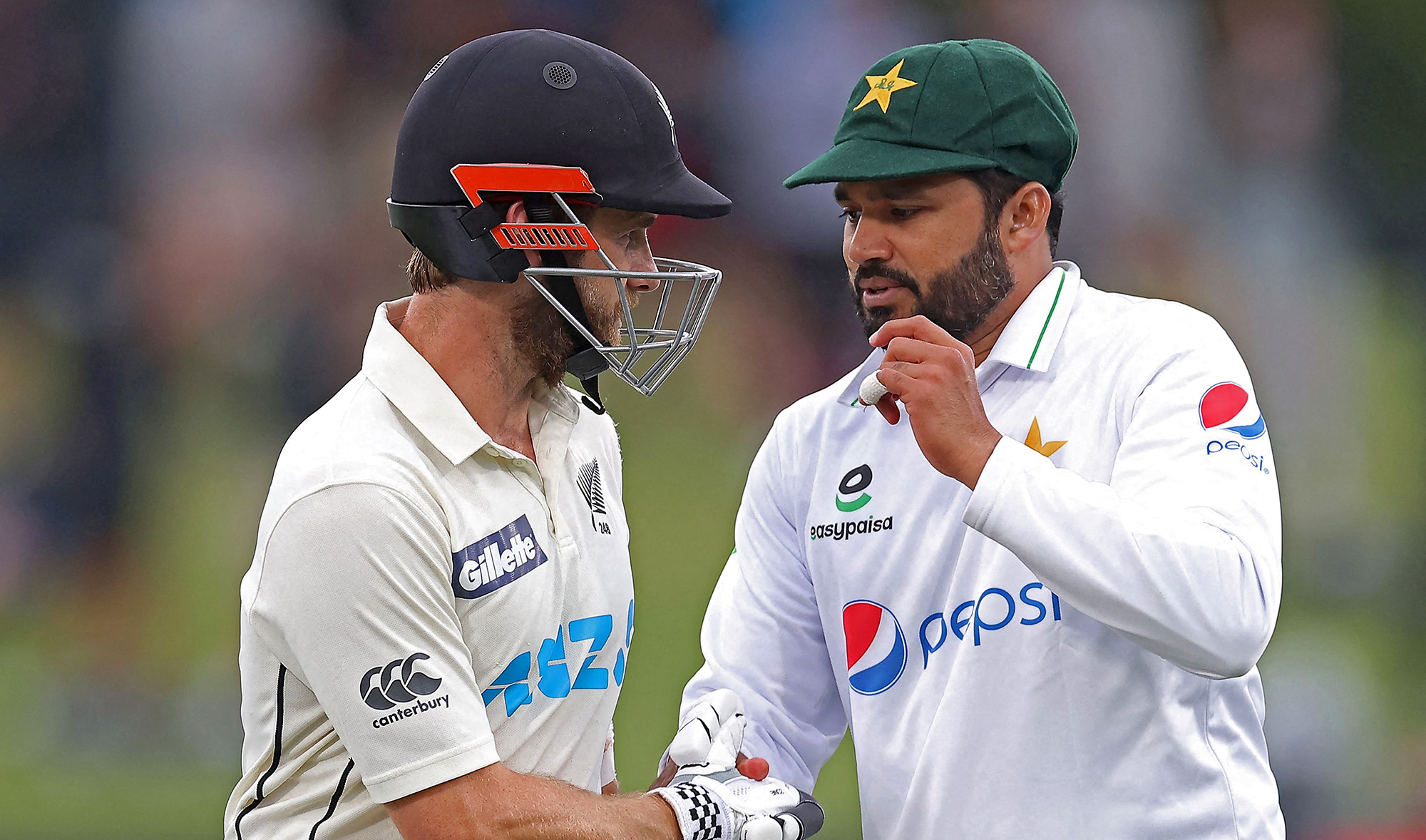 New Zealand's captain Kane Williamson (L) is greeted by Pakistan's Azhar Ali on day three of the second cricket Test match between New Zealand and Pakistan at Hagley Oval in Christchurch on January 5, 2021. (AFP)