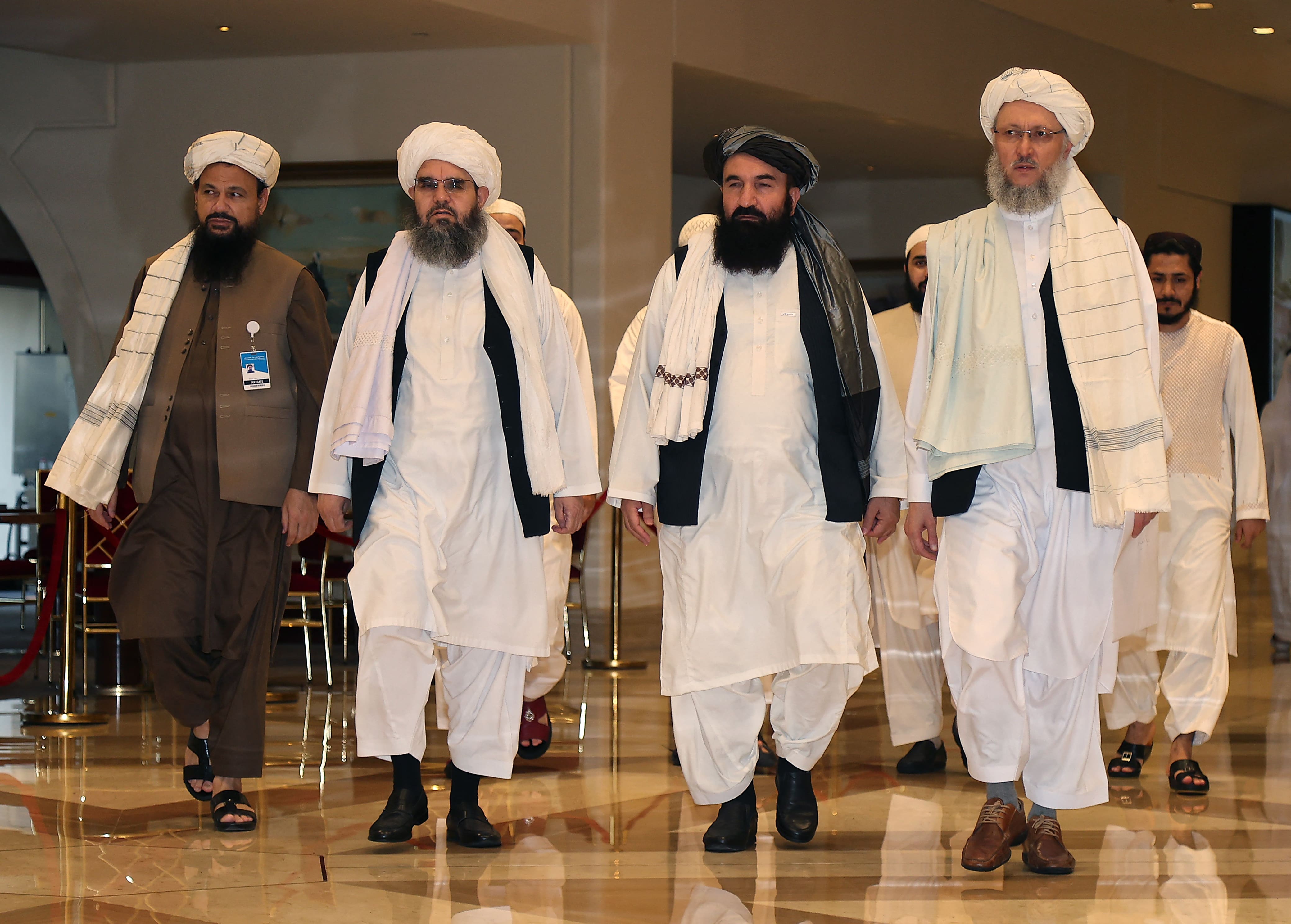 Head of the Taliban delegation Abdul Salam Hanafi (R), accompanied by Taliban officials (2R to L) Amir Khan Muttaqi, Shahabuddin Delawar and Abdul Latif Mansour, walks down a hotel lobby during the talks in Qatar's capital Doha on August 12, 2021. (AFP)