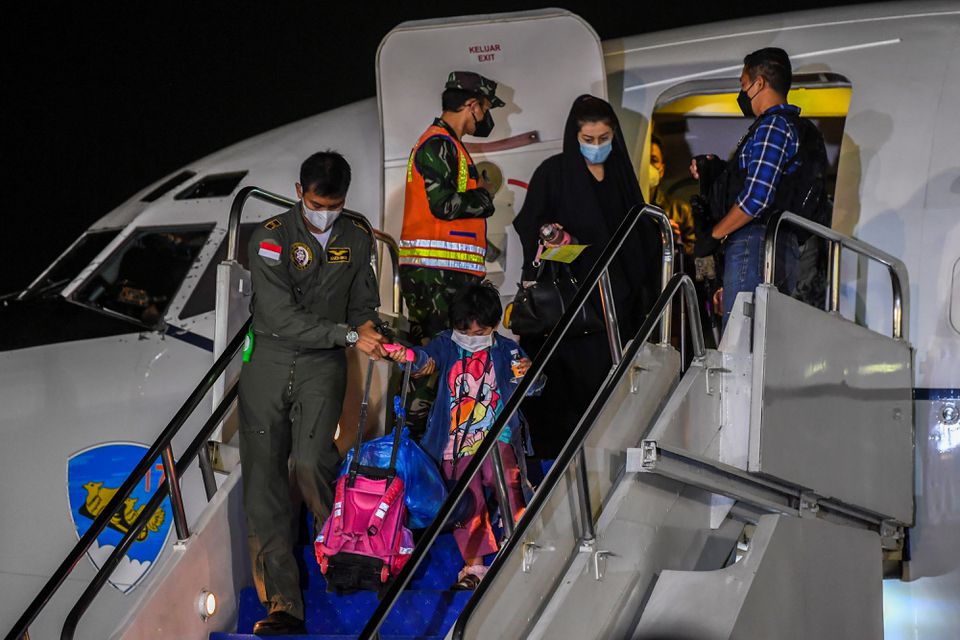 An Indonesian Airforce personnel helps a girl down the stairs of the aircraft as Indonesian citizens who were evacuated from Kabul, Afghanistan, arrive at Halim Perdanakusuma airbase in Jakarta, Indonesia, August 21, 2021. (REUTERS)
