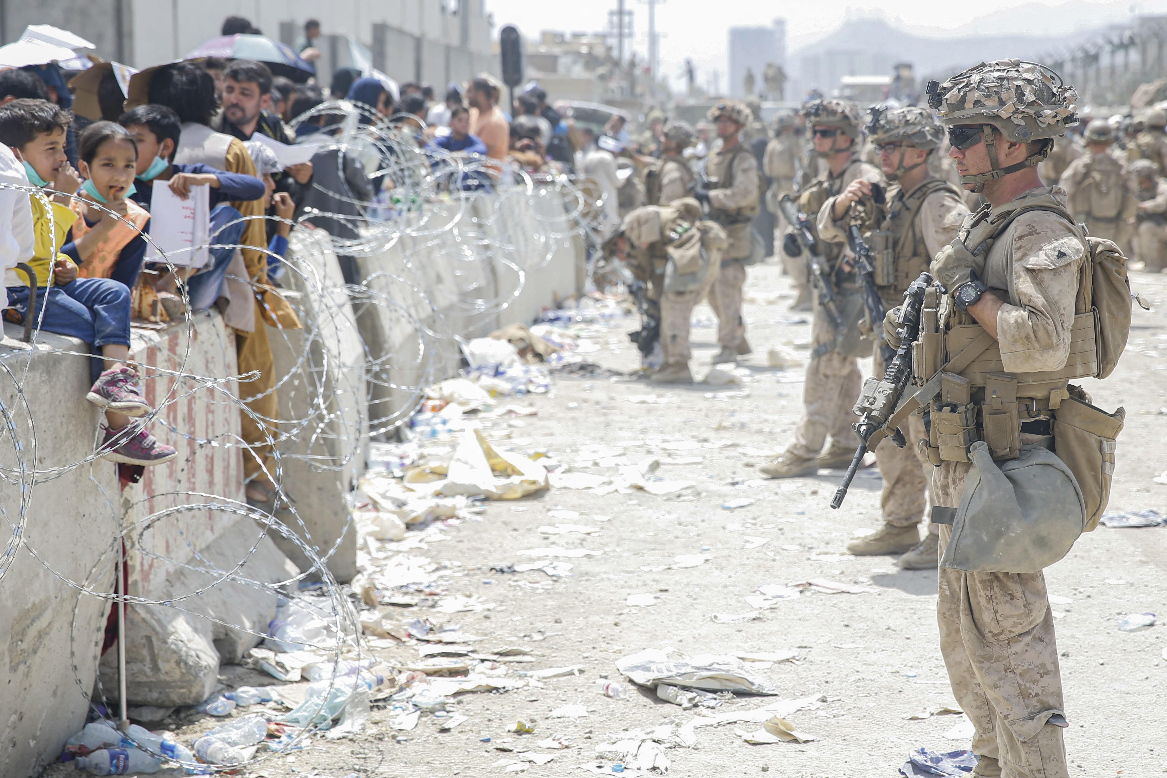 In this image courtesy of the US Marine Corps, US Marines with Special Purpose Marine Air-Ground Task Force - Crisis Response - Central Command, provide assistance during an evacuation at Hamid Karzai International Airport, Kabul, Afghanistan, on August 20, 2021. (AFP)