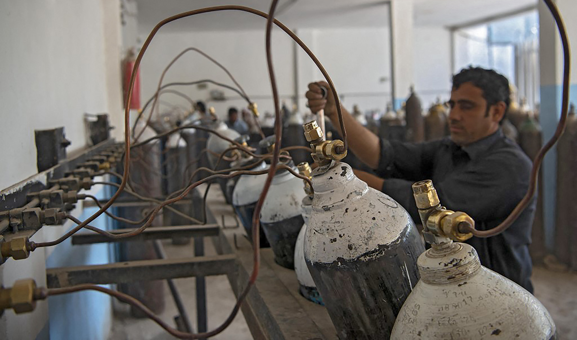 A worker fills oxygen cylinders for hospital use on coronavirus patients, at a factory in Peshawar, Pakistan on April 12, 2021. (AFP/File)