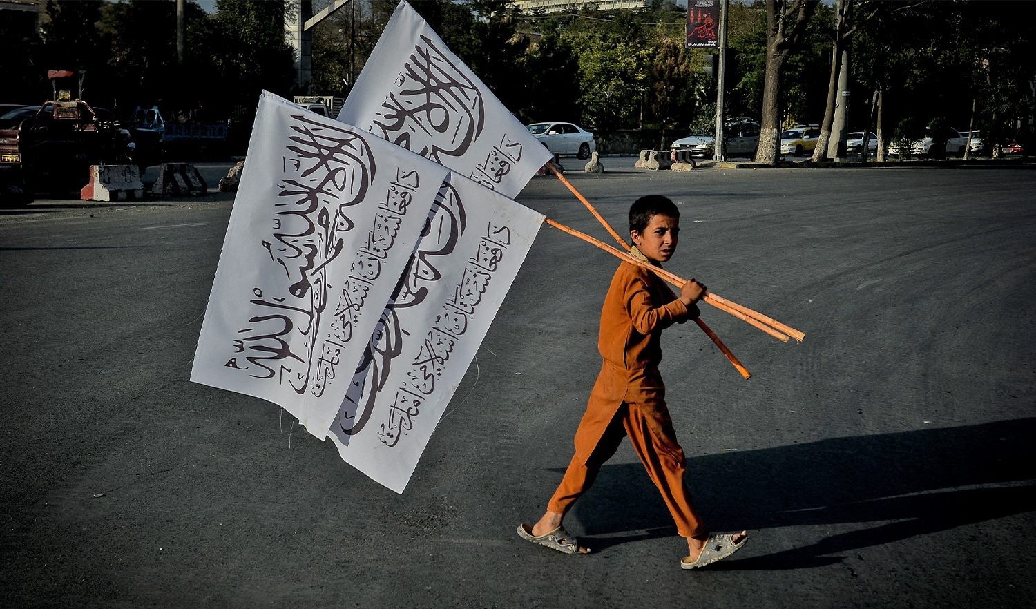 A boy carries Taliban flags to sell in the Karte Mamorin area of Kabul on August 22, 2021. (AFP)