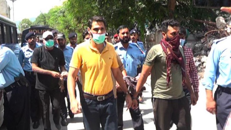 In this undated photo, employees of counselling center Therapy Works, wearing handcuff are led by Islamabad police officers to the court in Islamabad, Pakistan. (Photo courtesy: Social Media)