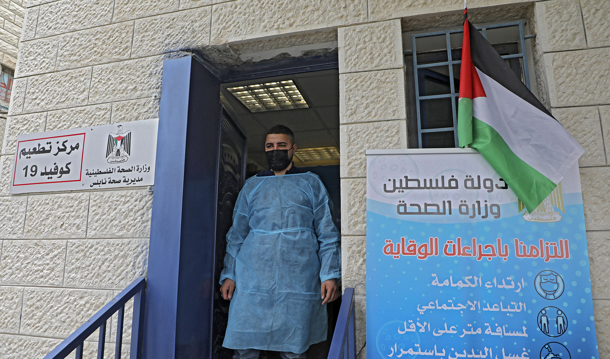 A Palestinian health worker stands at the entrance of a Covid-19 vaccination centre in the West Bank city of Nablus on March 22, 2021. (AFP/File)