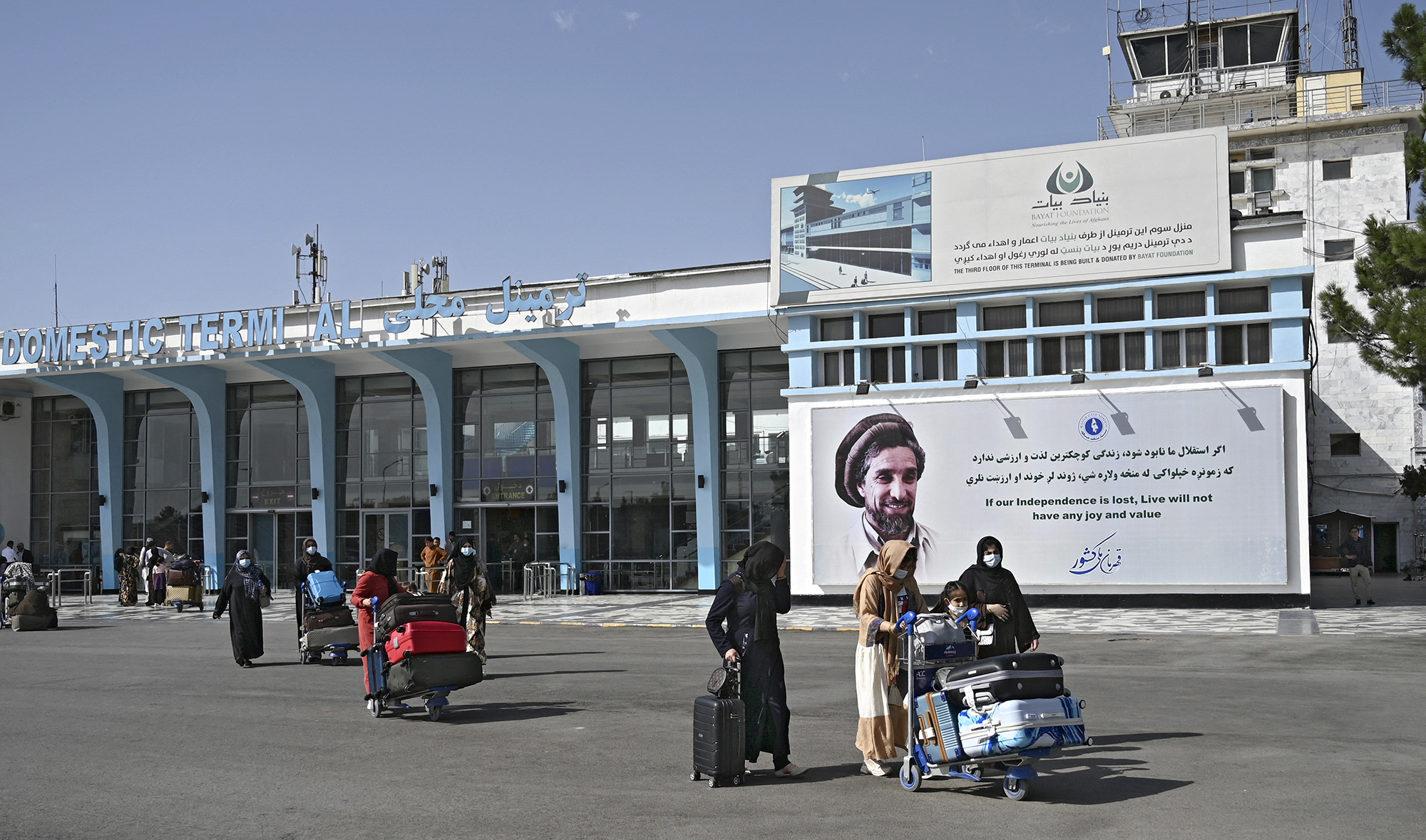 Afghan passengers carry their belongings as they come out from the domestic terminal, at the Kabul airport in Kabul, Afghanistan, on August 8, 2021. (AFP)