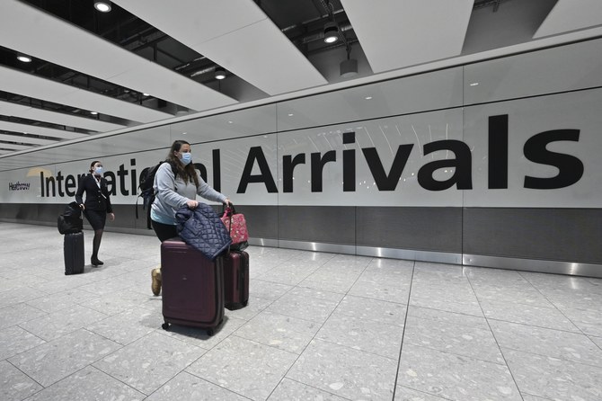 Passengers arrive with lugagge at the Terminal 5 international arrivals hall at London Heathrow Airport in west London on February 14, 2021. (AFP)