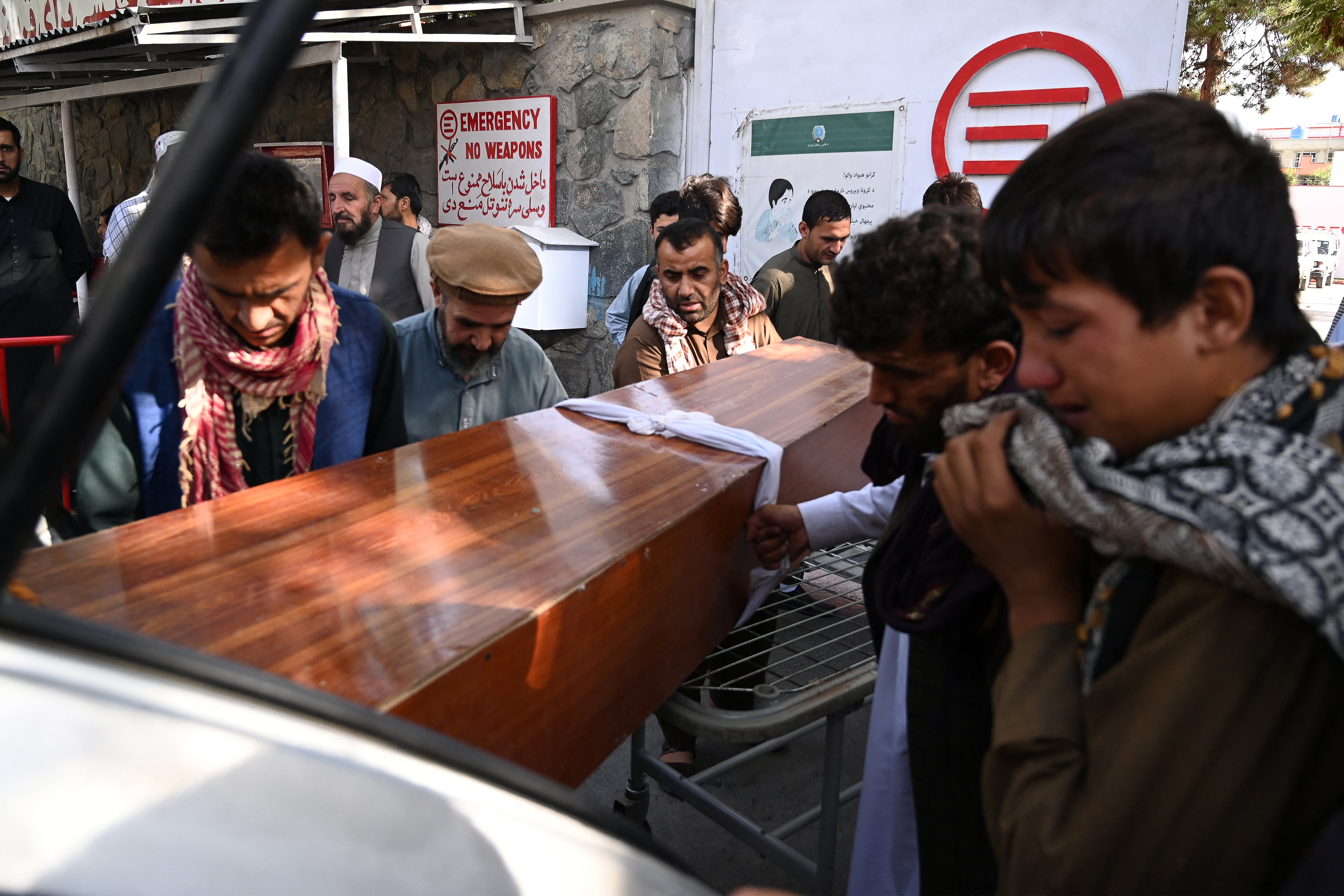 Relatives load in a car the coffin of a victim of the August 26 twin suicide bombs, which killed scores of people including 13 US troops outside Kabul airport, at a hospital in Kabul on August 27, 2021. (AFP)