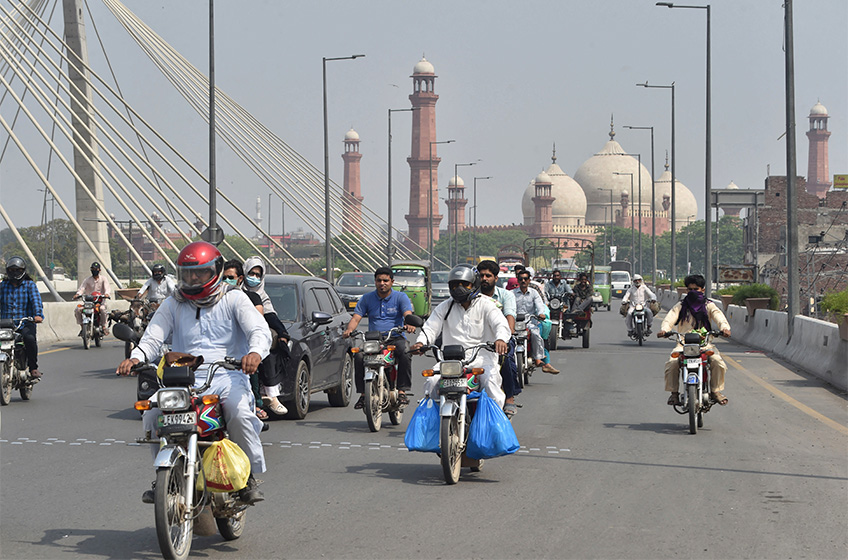 Commuters make their way along a street after the government eased a nationwide lockdown imposed as a preventive measure against the COVID-19 coronavirus, in Lahore on May 12, 2020. (AFP/ File)