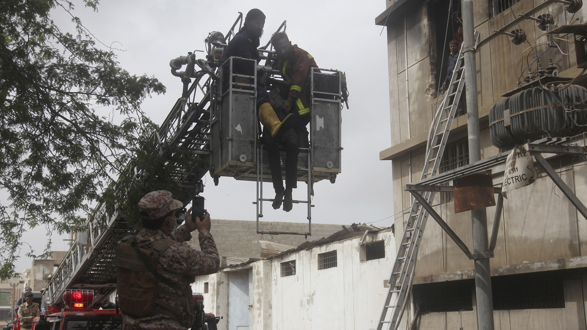 Rescue workers retrieve a body from a burnt chemical factory, in Karachi, Pakistan, Friday, Aug. 27, 2021. (AP)