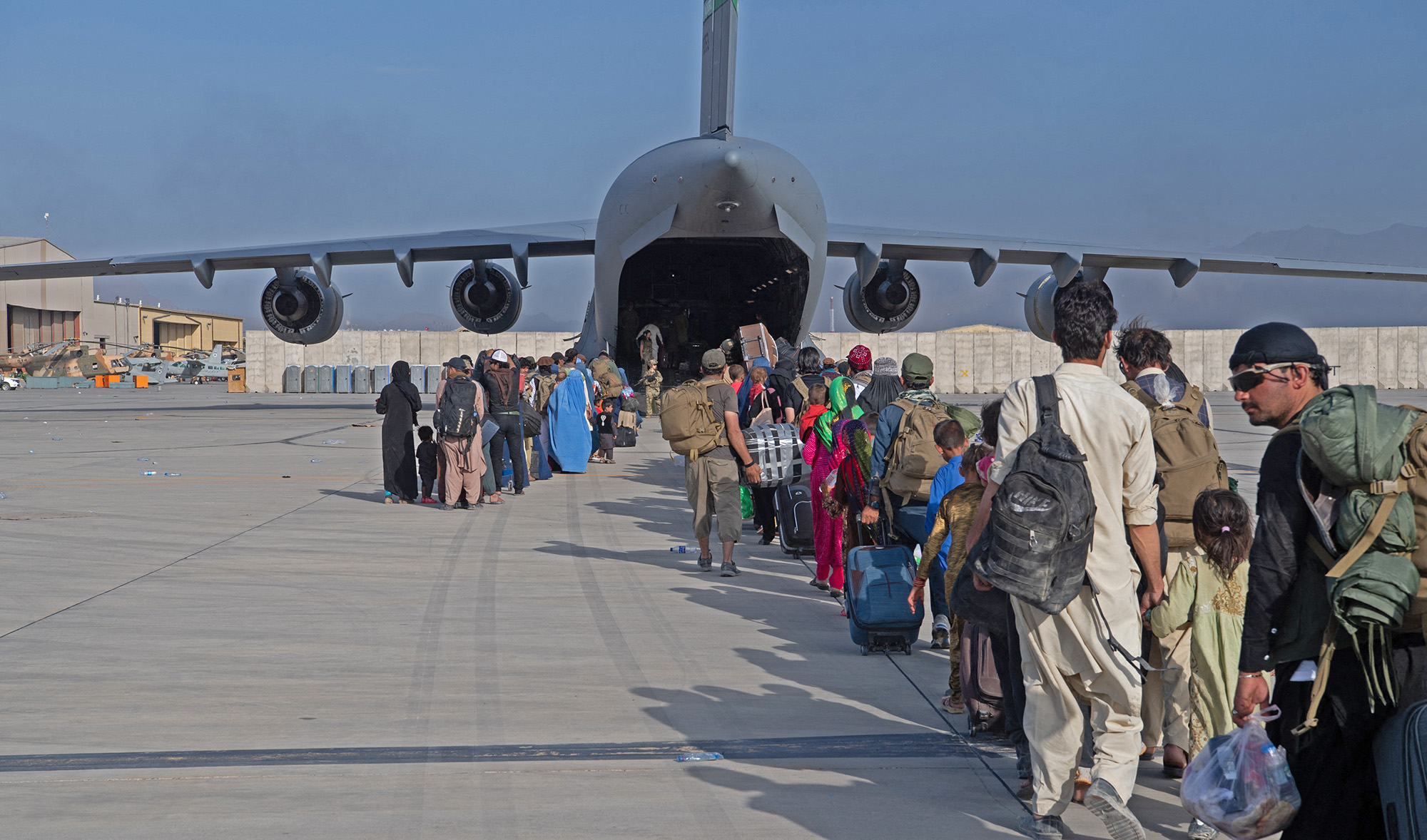 US Air Force loadmasters and pilots load passengers aboard a US Air Force aircraft in support of the Afghanistan evacuation at Hamid Karzai International Airport, Afghanistan on August 24, 2021. (AFP)