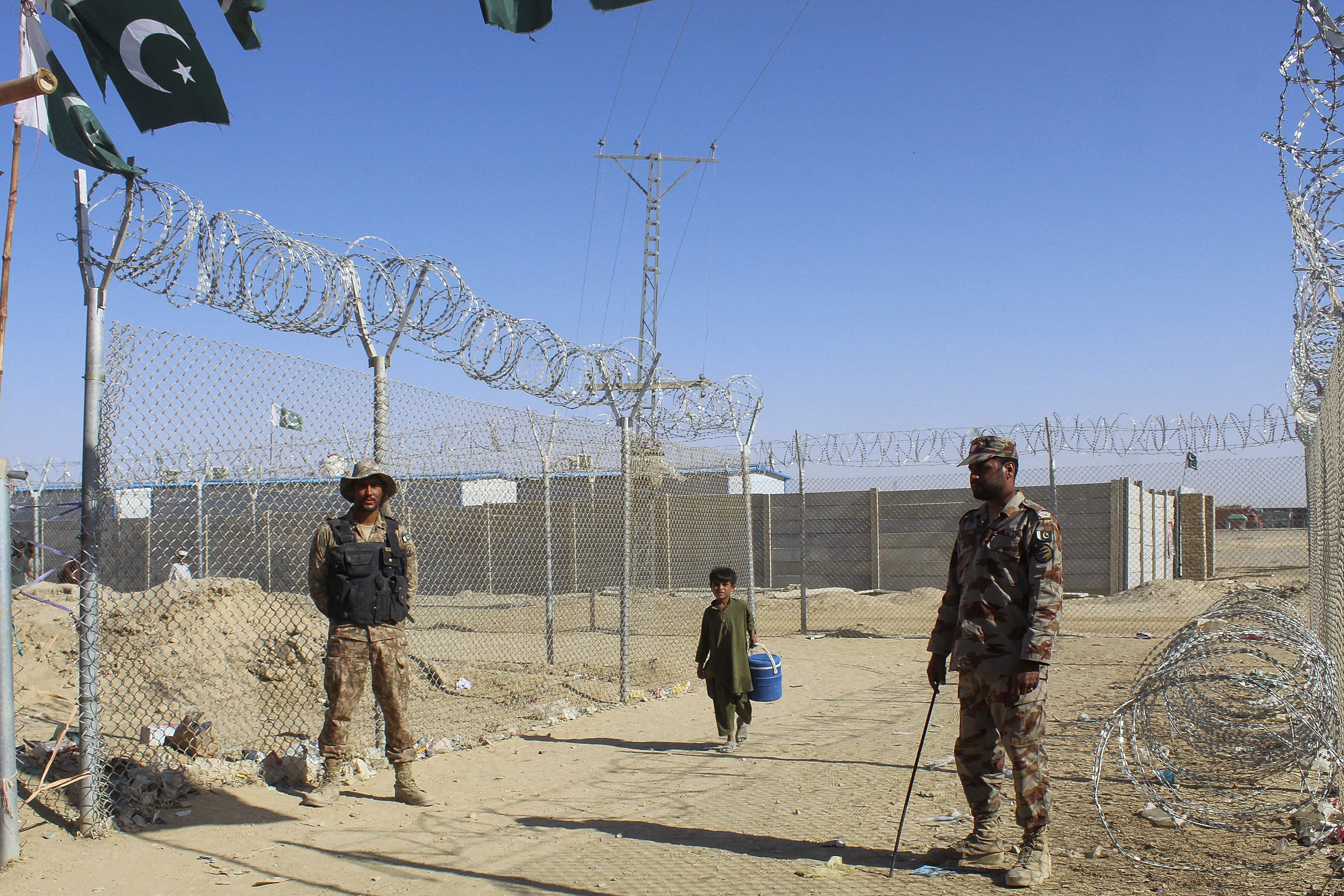 An Afghan boy walks by the fences guarded by the Pakistani paramilitary personnel at the Pakistan-Afghanistan border crossing point in Chaman on August 23, 2021 following Taliban's military takeover of Afghanistan. (AFP)