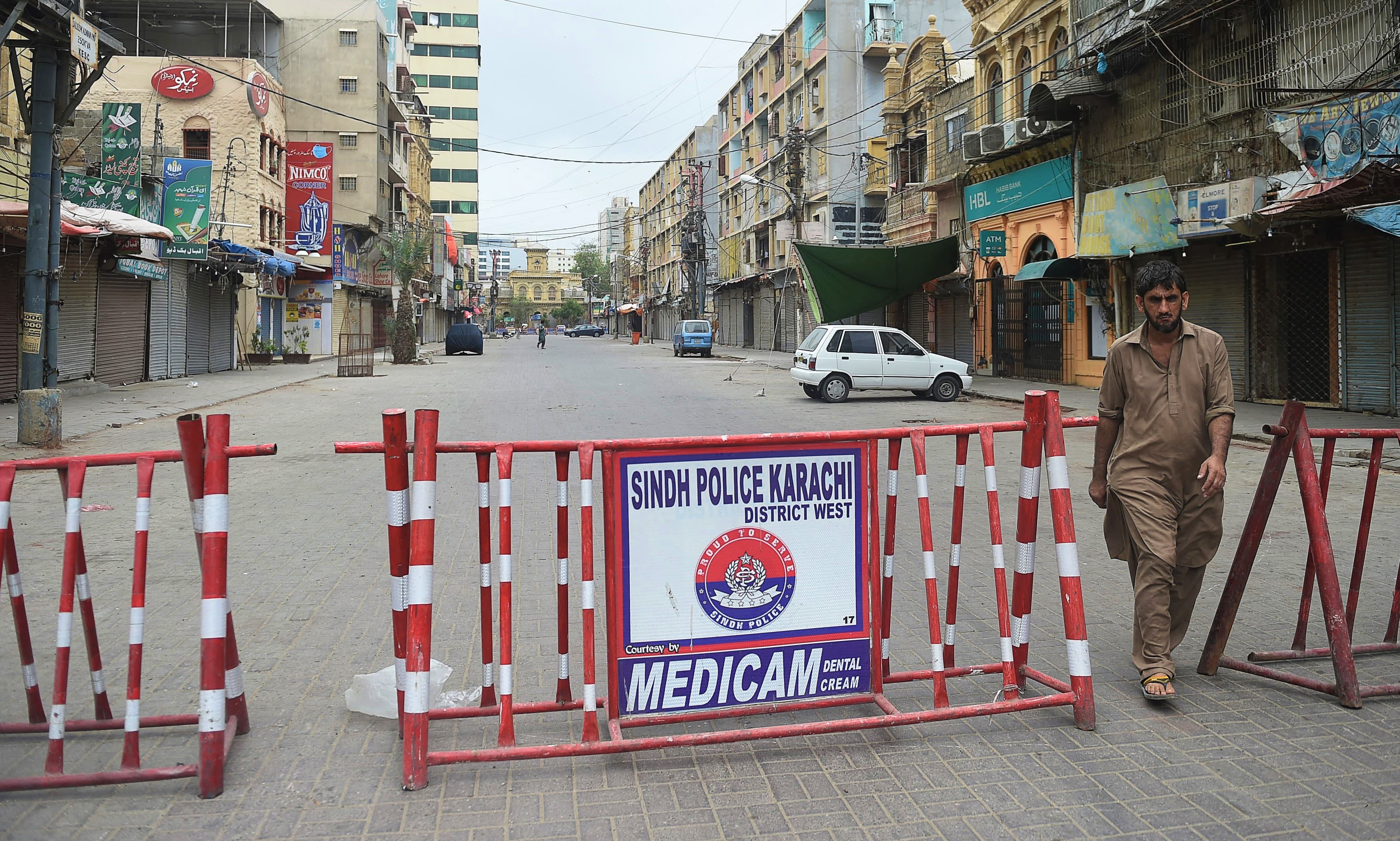 A man walks in a closed market as a partial lockdown was imposed to curb the spread of the Covid-19 coronavirus in Karachi on August 1, 2021. (AFP)