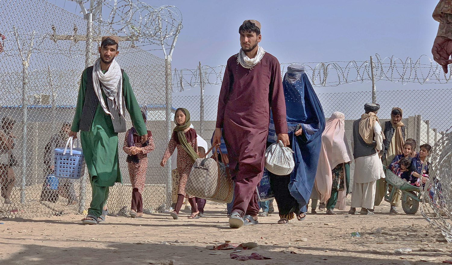 Afghans walk through a security barrier as they enter Pakistan through a border crossing point in Chaman, Pakistan, on August 26, 2021. (AP)