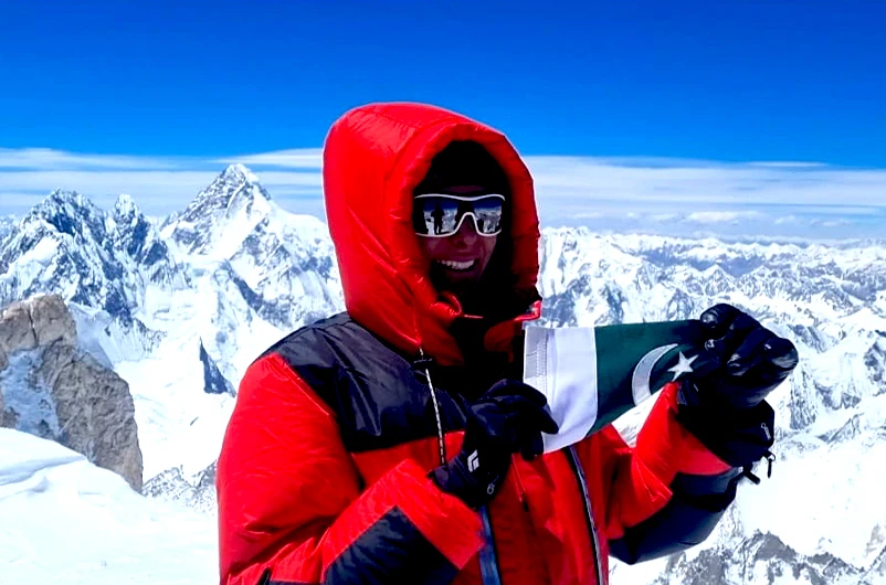 A Dubai-based Pakistani woman, Naila Kiani, waves her country's flag after summiting Gasherbrum II, located in District Shigar Gilgit–Baltistan region of Pakistan, on July 18, 2021. (Photo courtesy: Naila Kiani)