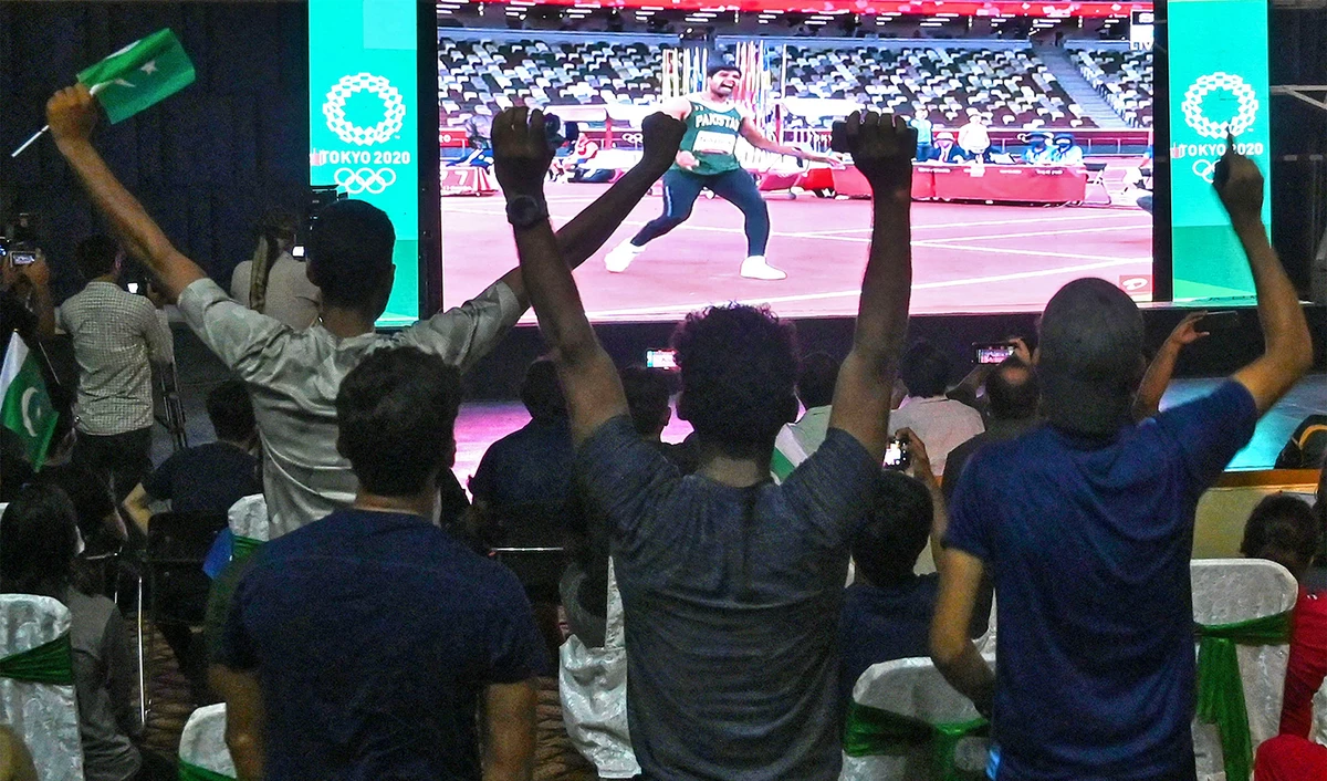 Supporters of Pakistan athlete Arshad Nadeem watch the Tokyo 2020 Olympic Games on a screen as he competes in the men's javelin throw final, in Lahore, Pakistan, on August 7, 2021. (AFP)