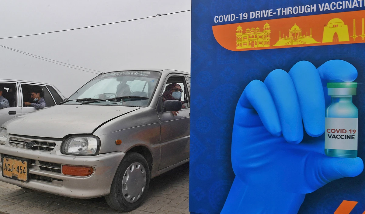 A woman awaits to receive a dose of the Sinopharm vaccine against the coronavirus, during a drive-through vaccination in Karachi on July 26, 2021. (AFP/File)