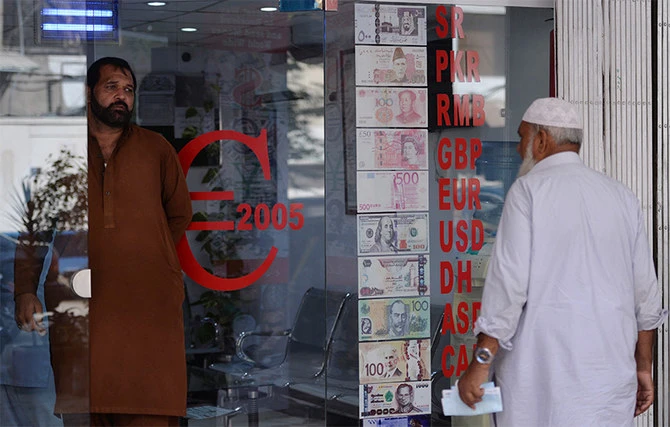 Pakistani customers enters at a currency exchange shop in Islamabad, Pakistan, on October 9, 2018. (AFP)