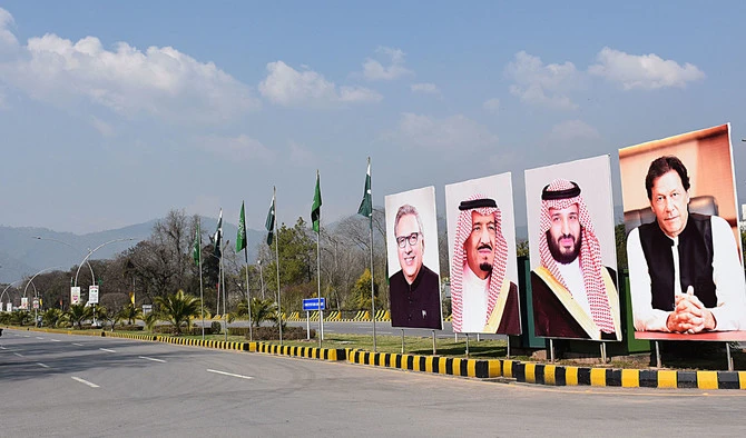 Pakistani commuters ride past billboards showing portraits of Saudi Arabian Crown Prince Mohammed bin Salman (2R) and Pakistan's Prime Minister Imran Khan (R) displayed on a roadside ahead of the prince's arrival in Islamabad on February 15, 2019. (AN Photo)
