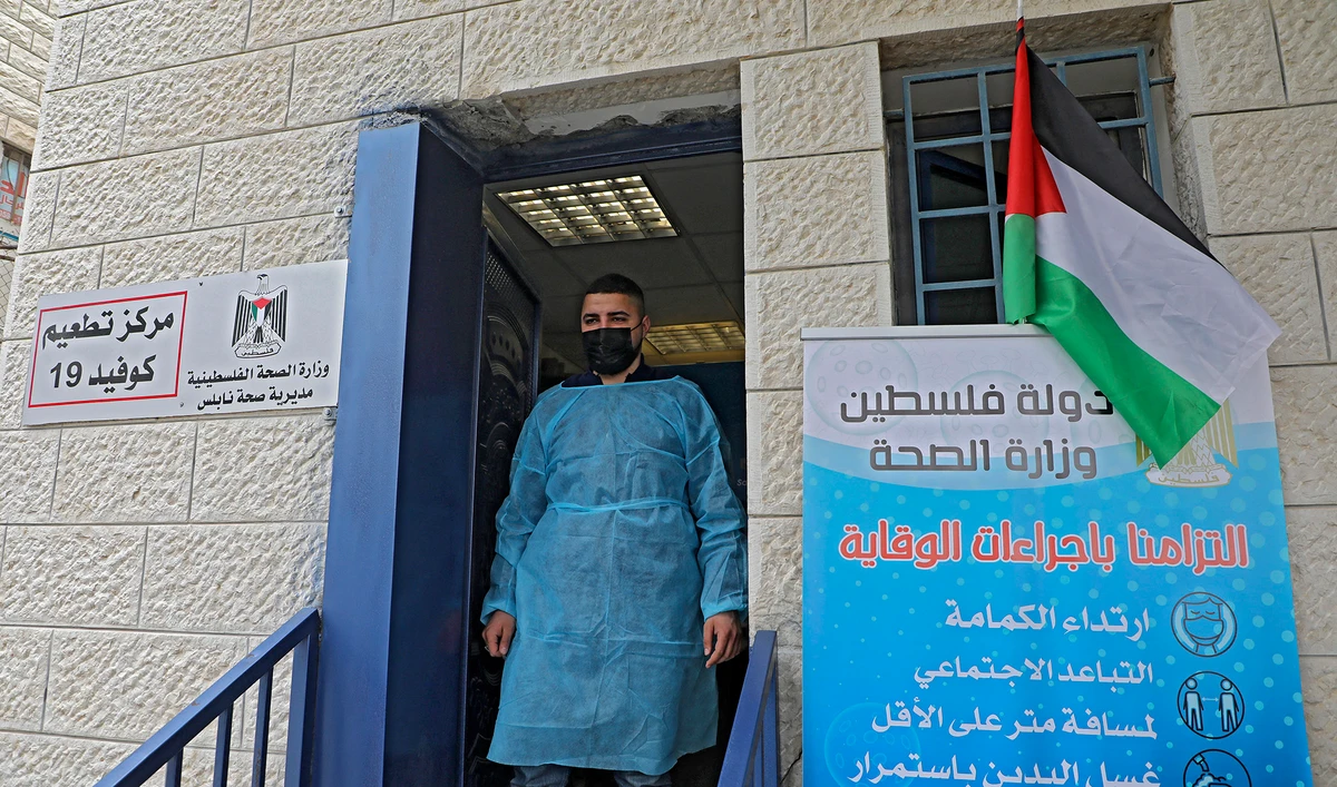 A Palestinian health worker stands at the entrance of a Covid-19 vaccination centre in the West Bank city of Nablus on March 22, 2021. (AFP/File)