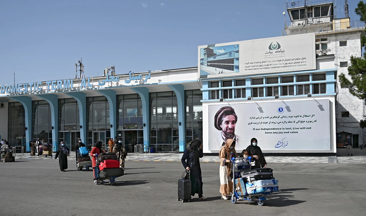 Afghan passengers carry their belongings as they come out from the domestic terminal, at the Kabul airport in Kabul, Afghanistan, on August 8, 2021. (AFP)
