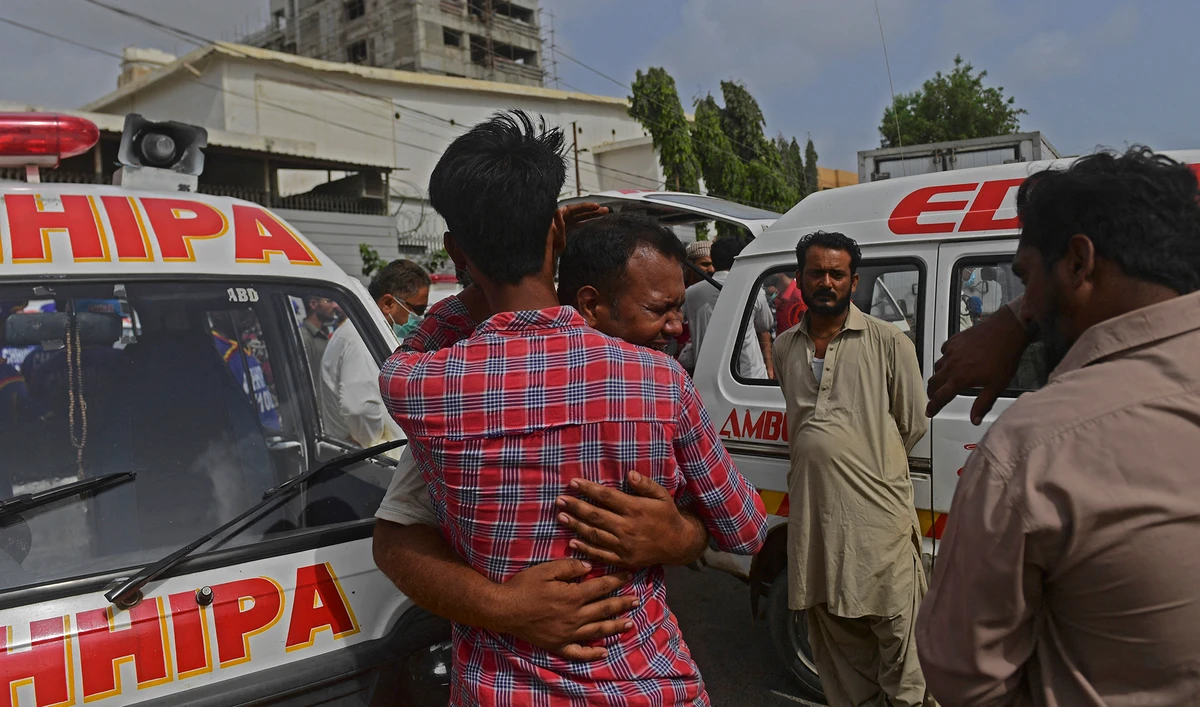 People mourn for their relatives who died in a factory fire in Karachi on August 27, 2021, as at least 16 workers died and more were missing after a factory fire in Pakistan's commercial capital Karachi, police said. (AFP)