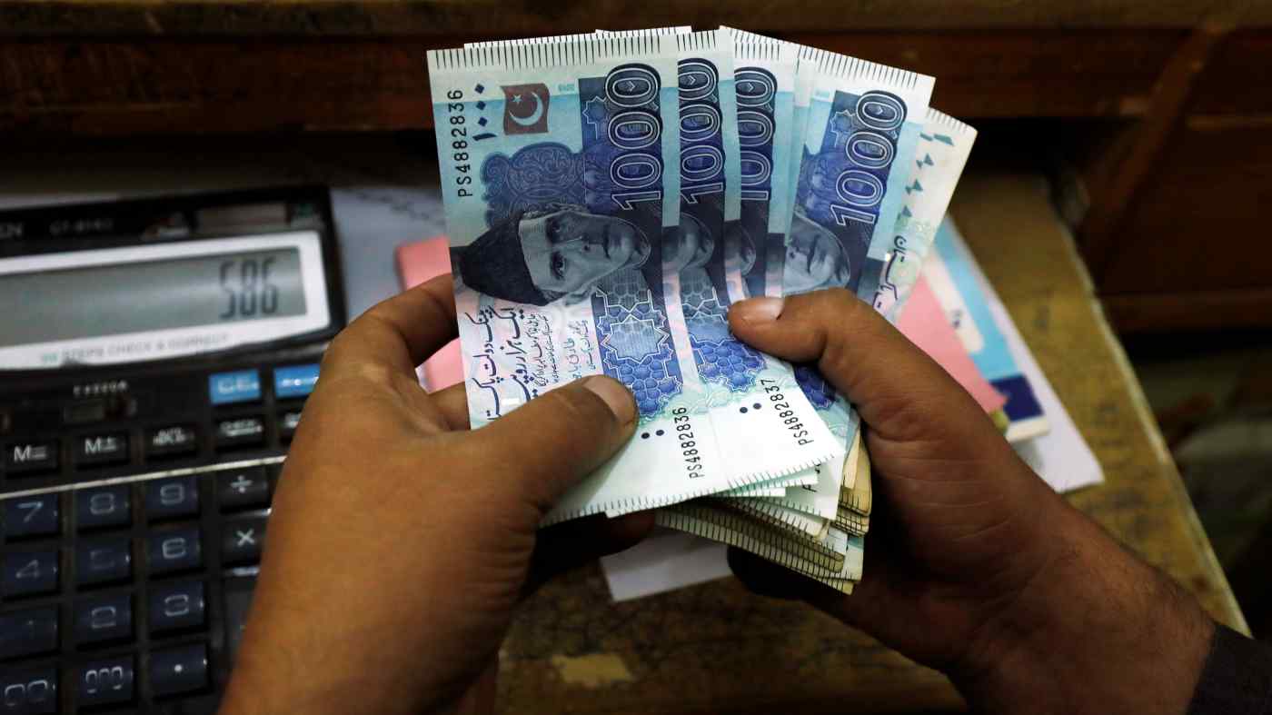 In this undated filed photo, a trader counts Pakistani rupee notes at a currency exchange booth in Peshawar, Pakistan. (REUTERS/File)