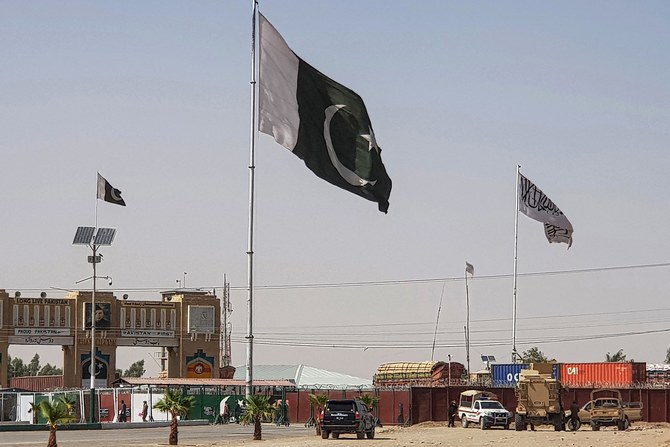 Pakistani flags (C) and Taliban flag (R) flutter on their respective border sides as seen from the Pakistan-Afghanistan border crossing point in Chaman on August 18, 2021. (AFP)