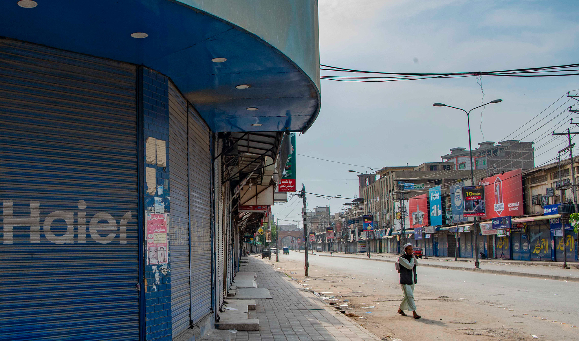 A man walks past shuttered shops in a closed commercial market area during lockdown, following new restrictions imposed as a preventive measure against the spread of the Covid-19 coronavirus, in Peshawar May 2, 2021. (AFP/File)