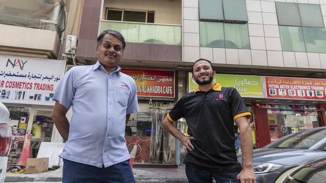 Pakistani Atif Mehmood (R), a salesman in Dubai poses in front of the residential building from which he saved a pregnant, cat stuck on the second floor balcony, on September 3, 2021. (AN Photo)