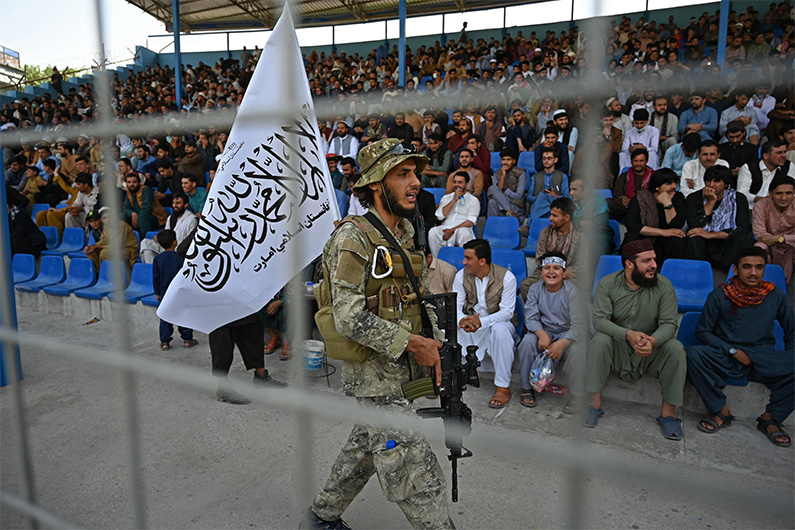 A Taliban fighter keeps vigil as spectators watch the Twenty20 cricket trial match being played between two Afghan teams 'Peace Defenders' and 'Peace Heroes' at the Kabul International Cricket Stadium in Kabul on September 3, 2021. (AFP)