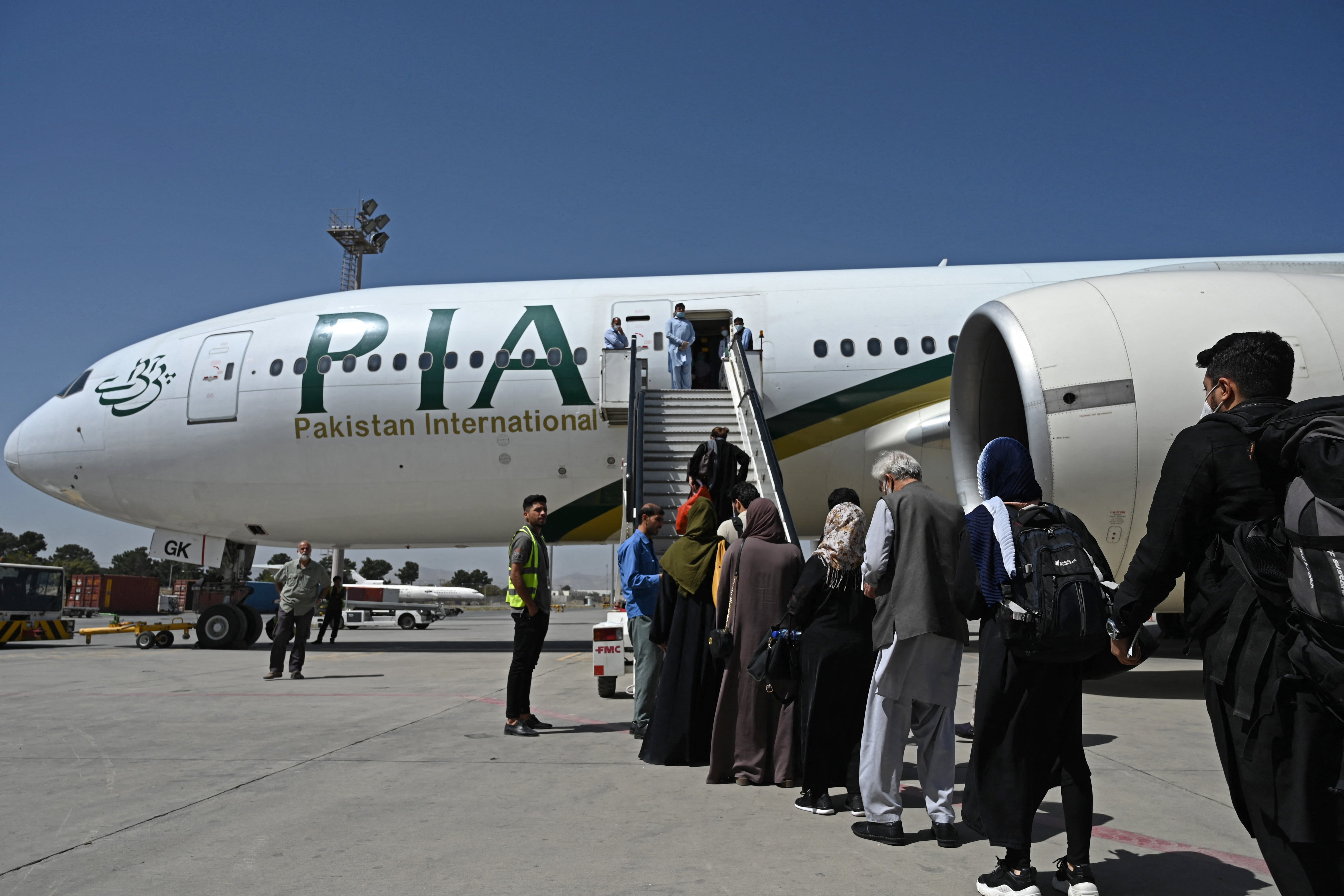Passengers board a Pakistan International Airlines (PIA) flight, the first commercial international flight since the Taliban retook power last month, at the airport in Kabul on September 13, 2021. (AFP)