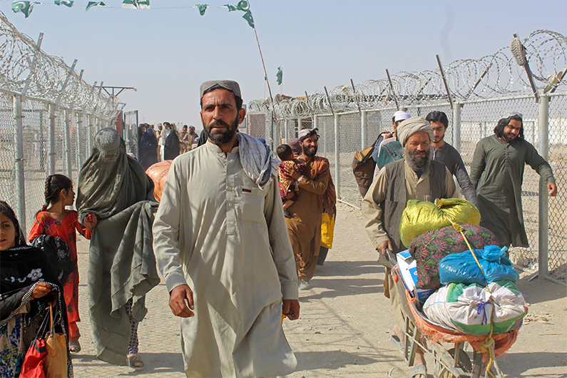 Afghan nationals walk at the Pakistan-Afghanistan border crossing point in Chaman on August 20, 2021, to return back to Afghanistan. (AFP)