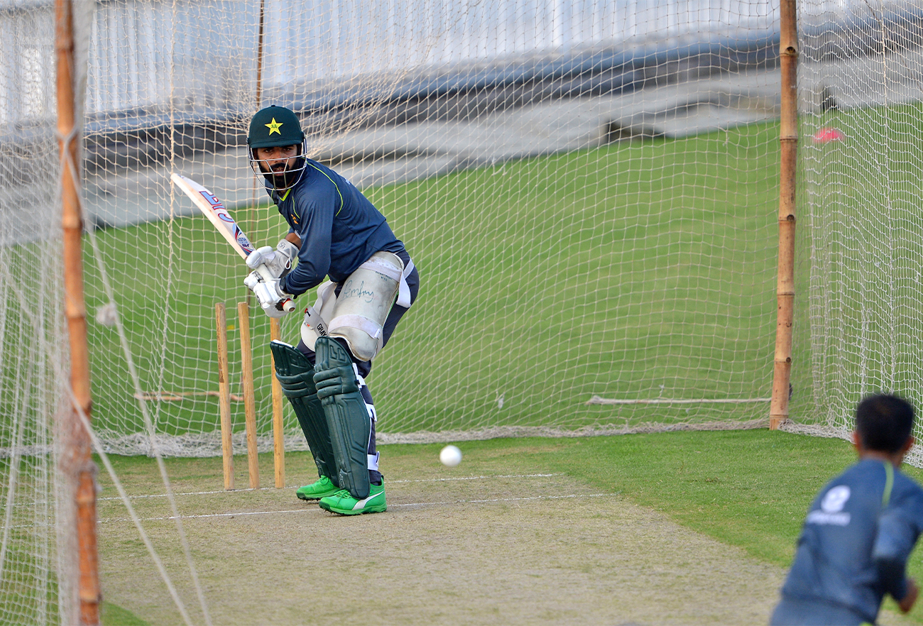 Pakistan's Shadab Khan (L) views the ball before hitting during a practice session at the Rawalpindi Cricket Stadium in Rawalpindi, Pakistan, on September 14, 2021. (AFP)
