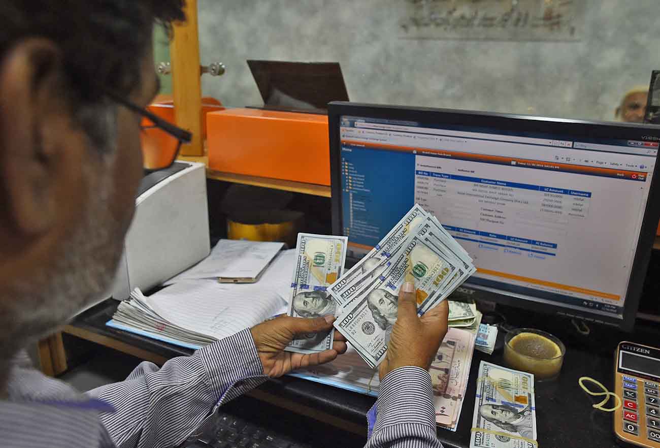 A Pakistani dealer counts US dollars at a currency exchange shop in Karachi, Pakistan, on November 30, 2018. (AFP/File)