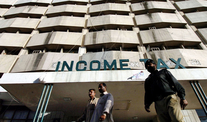 Pakistani men walk in front of the income tax building in Karachi, 05 April 2005. (AFP/ File)