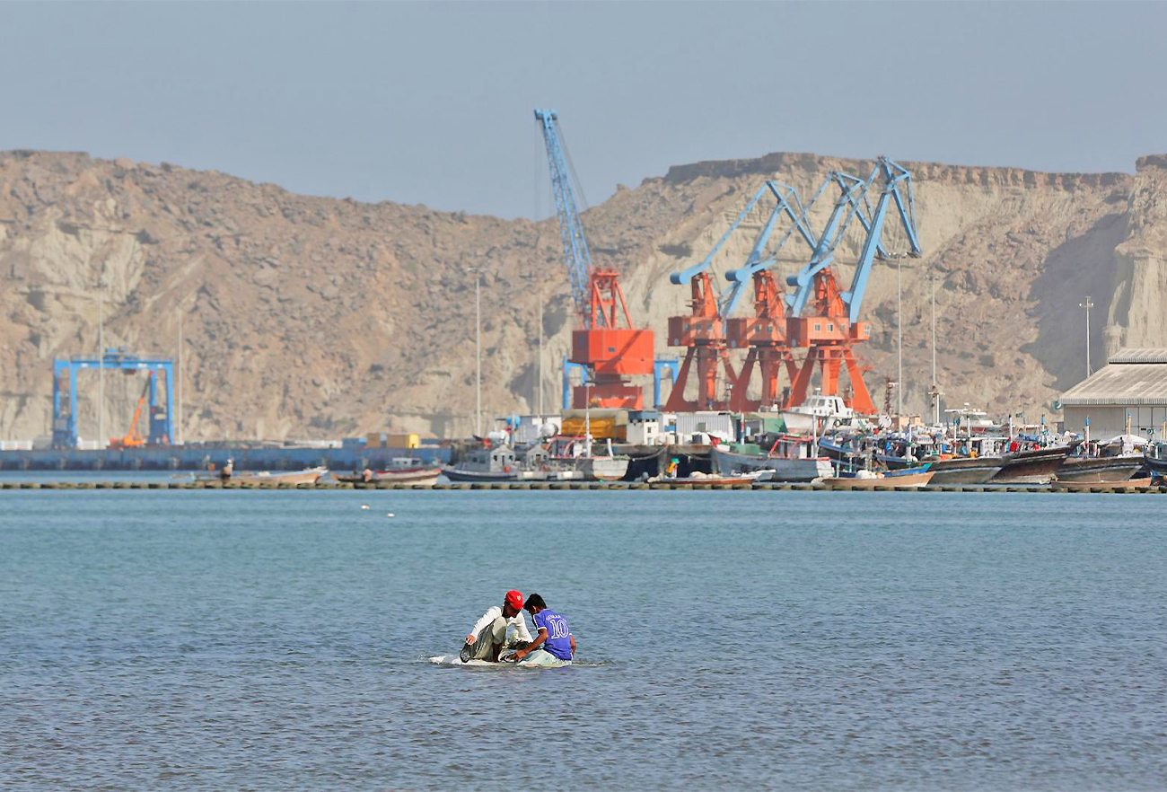 Boys sit on a piece of styrofoam sheet as they search for crabs in front of the Gwadar port, Pakistan, on April 11, 2017. (REUTERS)