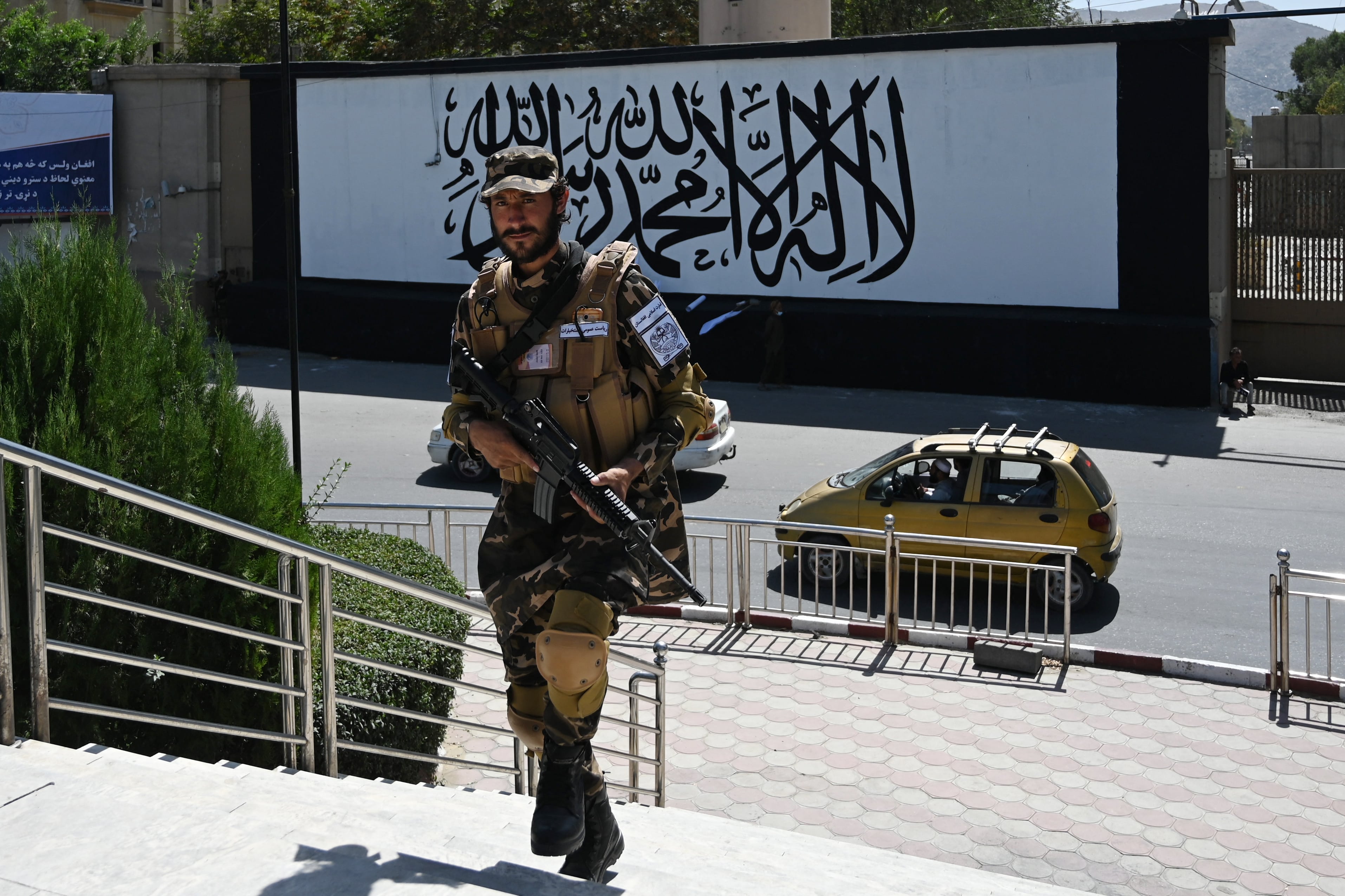 A member of the Taliban Fateh, a "special forces" unit, stands guard outside the US embassy in Afghanistan displaying a Taliban flag in the outer concrete wall in Kabul on September 8, 2021. (AFP)