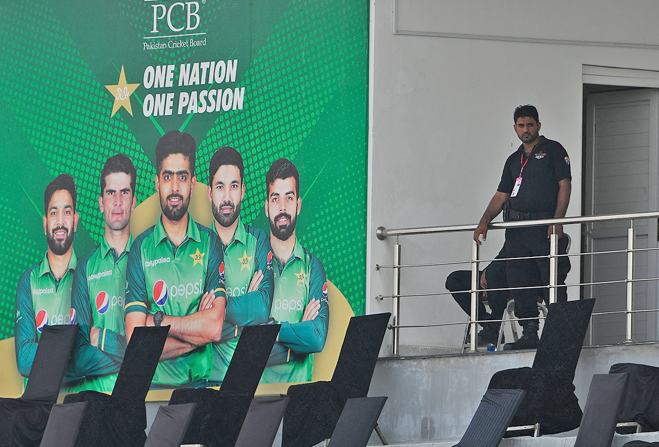 A policeman stands guard next to a poster featuring Pakistan's cricket players at the Rawalpindi Cricket Stadium in Rawalpindi on September 17, 2021. (AFP/File)