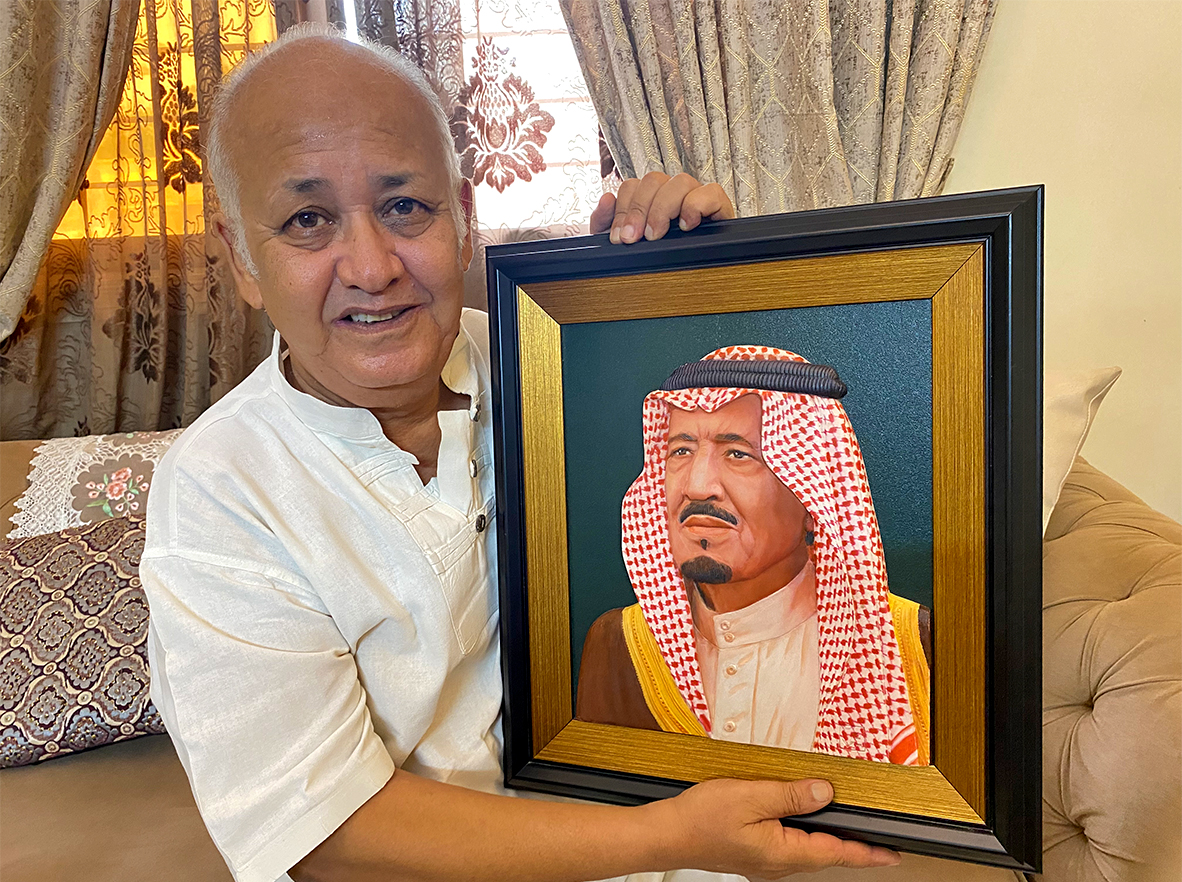 A Pakistani artist Khalil Najmi holds a portrait of King Salman bin Abdul Aziz at his residence in Karachi, Pakistan, on September 21, 2021. (AN Photo)