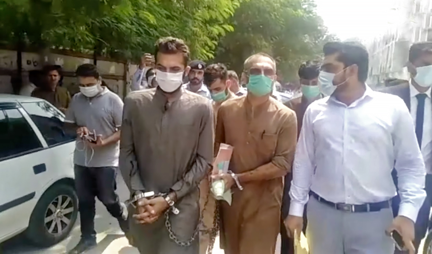 Handcuffed Zakir Jaffer, left, key suspect in the July murder of Noor Mukadam, and his father, front center, are seen outside a court in Islamabad on September 6, 2021. (Photo courtesy: Social Media)