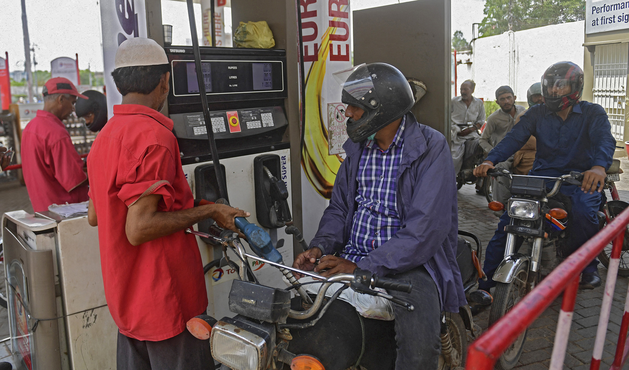 An employee of a gas station fills the tank of a motorbike in Karachi on July 16, 2021, following an increase of petroleum prices by the government. (AFP/File)
