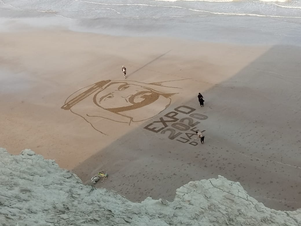Three Pakistani artists, Zubair Mukhtar, Hussain Zaib and Bahar Ali Gohar, pose with the portrait of the United Arab Emirates ruler Sheikh Mohammed Bin Rashid Al-Maktoum which they sketched on the Pasni beach in Pakistan's southwestern Balochistan province on September 22, 2021. (Photo courtesy: Zubair Mukhtar)