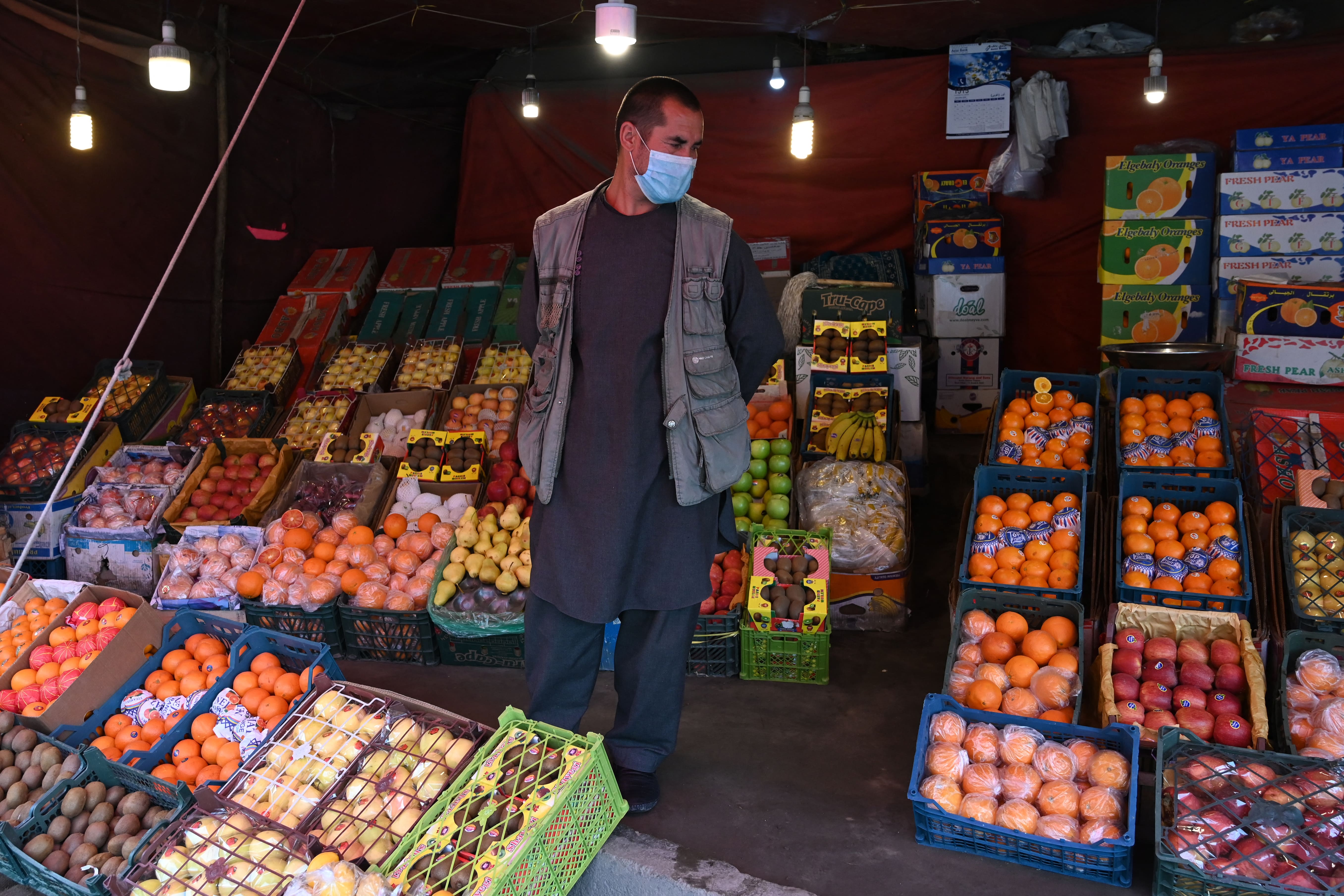 In this photo taken on April 20, 2020 a fruit vendor wearing a facemask waits for customers during a government-imposed lockdown on the capital city as a preventive measure against the COVID-19 coronavirus, at his fruit shop in Kabul. (AFP)