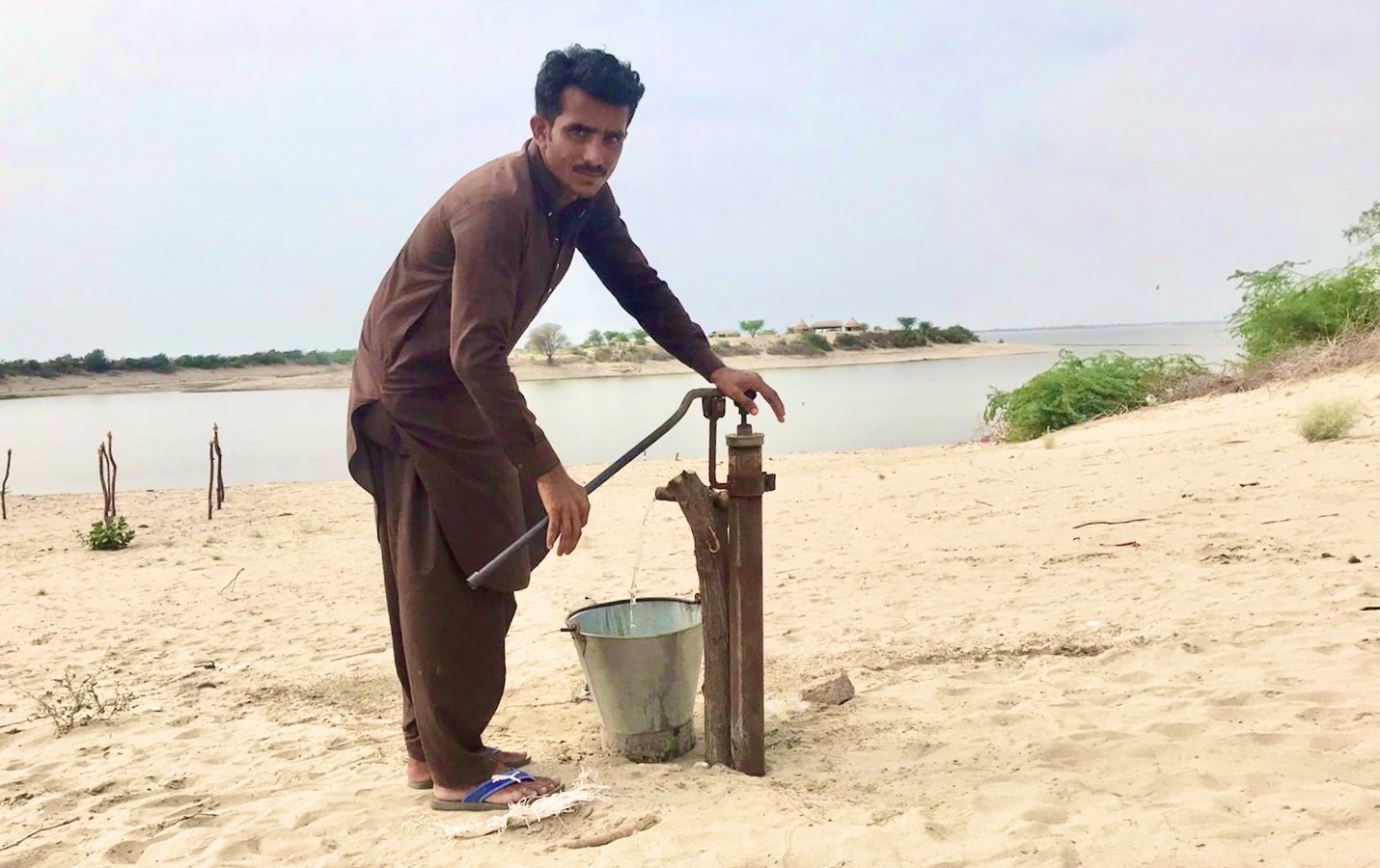 A local fills a water bucket near the Chotiari water reservoir in Sindh's Sanghar district, Pakistan, on September 19, 2021. (AN photo by Zulfiqar Kunbhar)